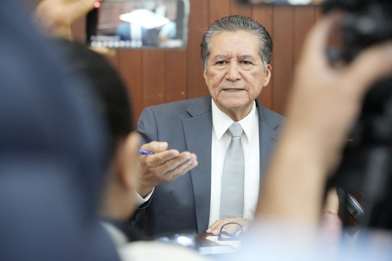 Diputado Feliciano Castro aparece al fondo, entre cámaras y periodistas.