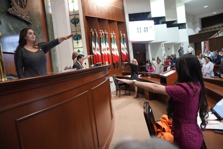 Nuevas integrantes de Mesa Directiva rinden protesta levantando su brazo.