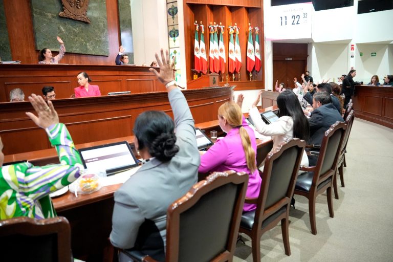 Diputadas y diputados votan levantando sus manos desde sus asientos, frente a la Mesa Directiva.