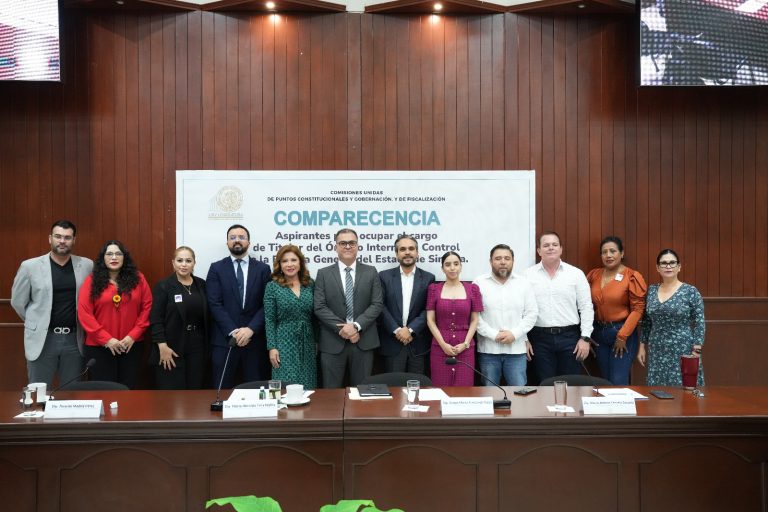 Personas aspirantes posan tras presidium con diputadas y diputados.