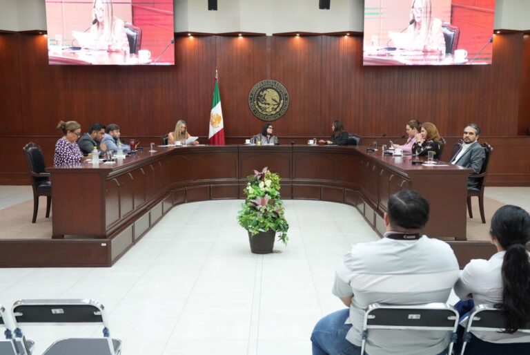 Diputados están sentados en sus lugares. Al fondo escudo del Congreso y dos pantallas de televisión en lo alto.