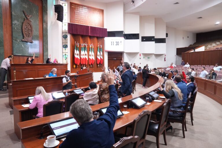 Diputadas y diputados votan levantando sus manos desde sus respectivos lugares en sesión extraordinaria.