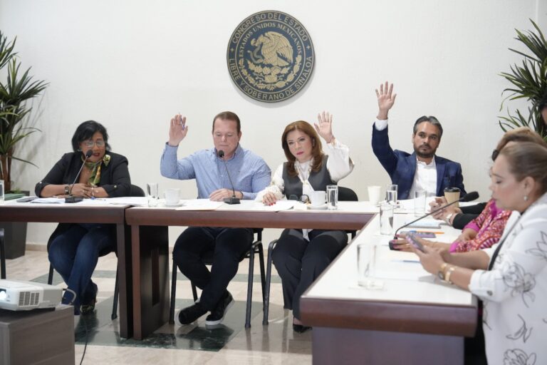 Cuatro integrantes de Comisión de Educación votan levantando sus manos durante reunión de trabajo en el lobby del Salón de Sesiones.