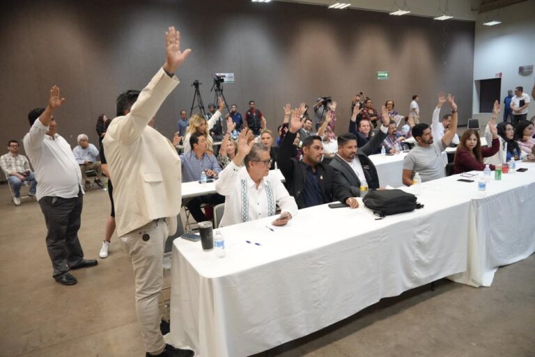 En sede alterna diputados y diputadas votan levantando sus manos.