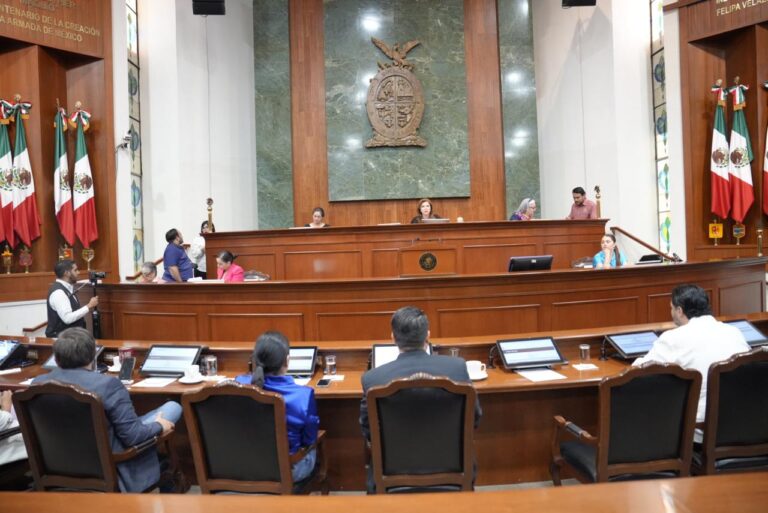 Foto frontal del Salón de Sesiones Aparecen diputados de espalda y al fondo quienes integran la Mesa Directiva.
