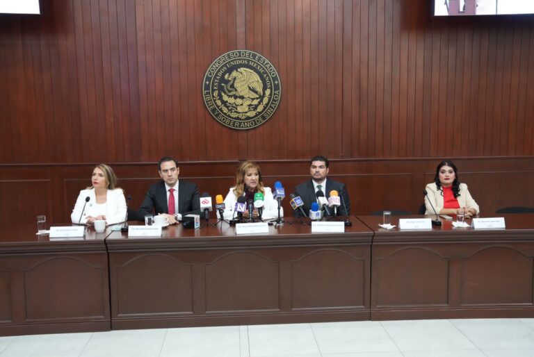 Diputadas y diputados representantes de distintos partidos están sentados en mesa con micrófonos, donde dan conferencia.