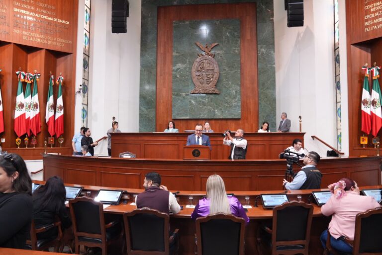 Foto con diputadas y diputados sentados en sus curules. Aparecen de espaldas. Frente a ellos, en el fondo. la Mesa Directiva.