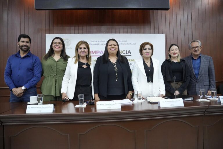 Diputadas y diputados posan de pie para la foto con la funcionaria compareciente.