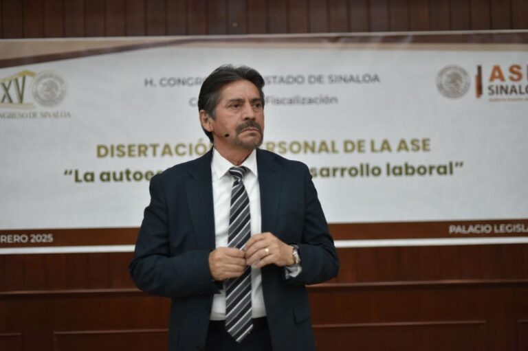 Diputado Eligio López habla y al fondo lona con el título de su charla.