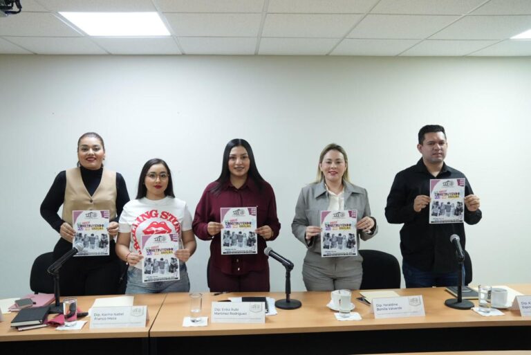 Integrantes de la Comisión muestran carteles del evento a realizar.