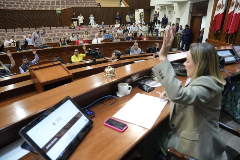 Diputadas y diputados votan levantando su mano. En primer plano,. la presidenta de la Mesa Directiva.