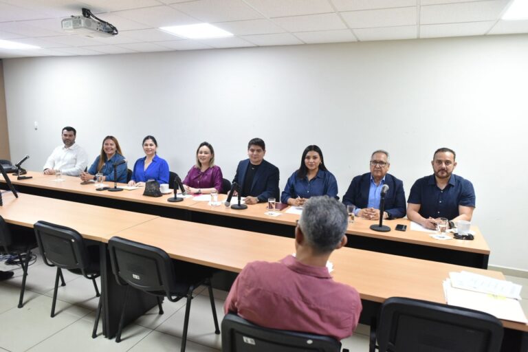 Diputadas y diputados sentados en larga mesa durante reunión de trabajo.