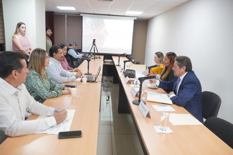 Integrantes de la Comisión están sentados en una mesa y frente a ellos, en otra mesa, delegación de Icatsin.