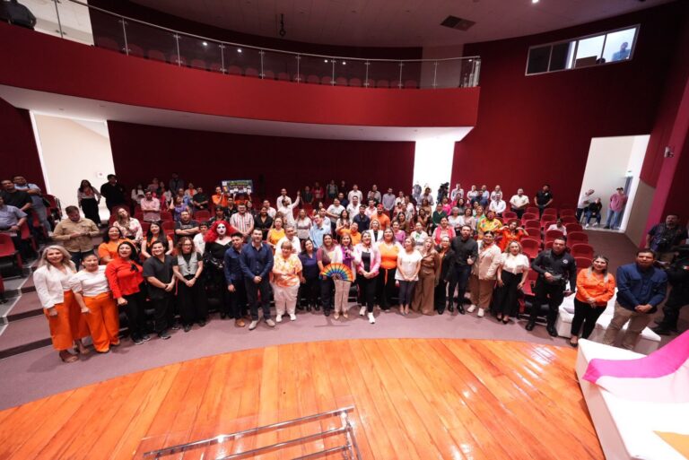 Participantes en panel posan para foto grupal en auditorio de la UAIM.
