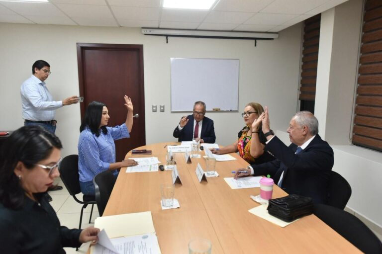 Integrantes de la Comisión de Hacienda votan levantando sus manos.