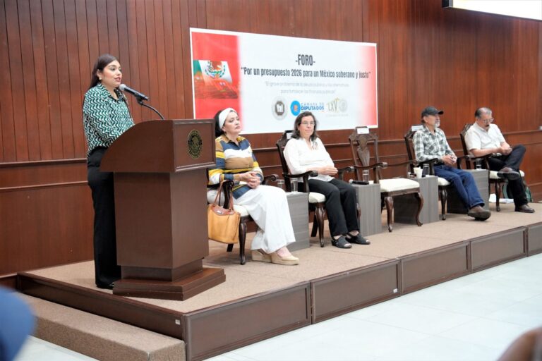 Diputada Monserrat López López, del PT, habla en podiulm, junto a presidium, durante el foro.