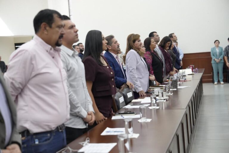 Diputadas y diputados permanecen de pie mientra guardan un minuto de silencio.
