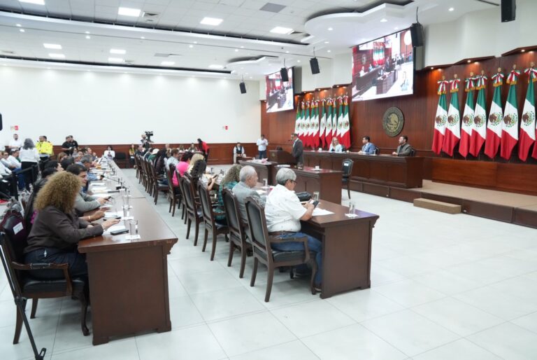 Eh hileras, diputadas y diputados aparecen sentados en sus mesas y enfrente tienen a la Mesa Directiva.