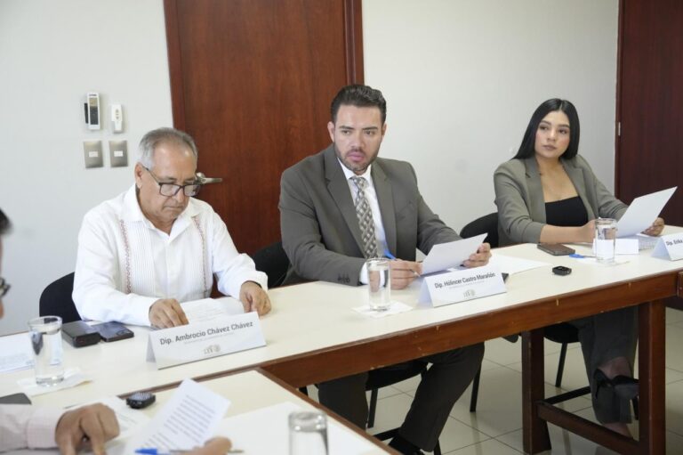 El nuevo presidente aparece sentado entre diputado y diputada.