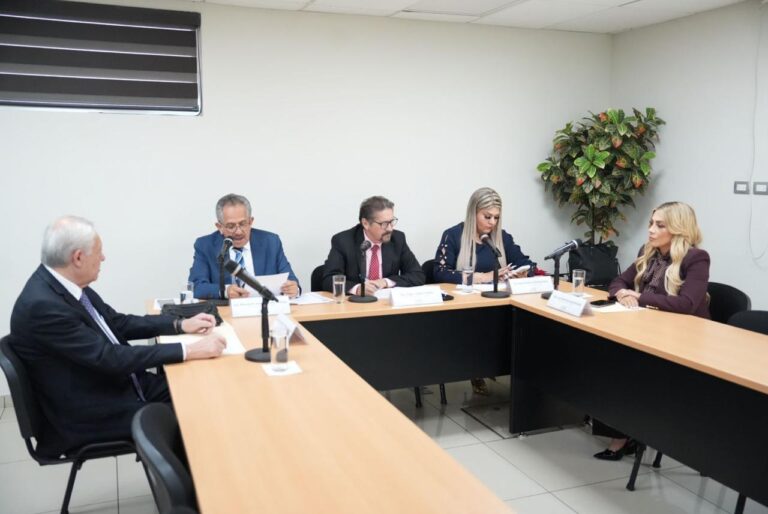 Integrantes de la Comisión revisan documento por aprobar.