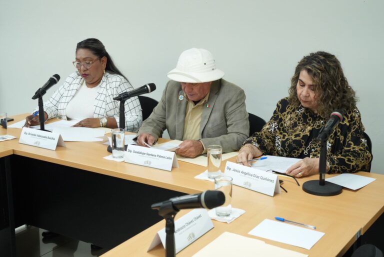 Tres integrantes de la Comisión sesionan en pequeña sala.