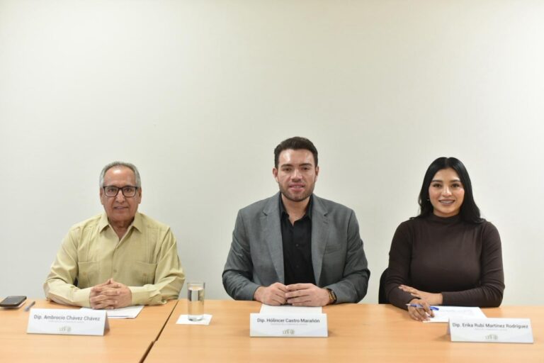 Tres integrantes de la comisión sesionan en pequeña sala.