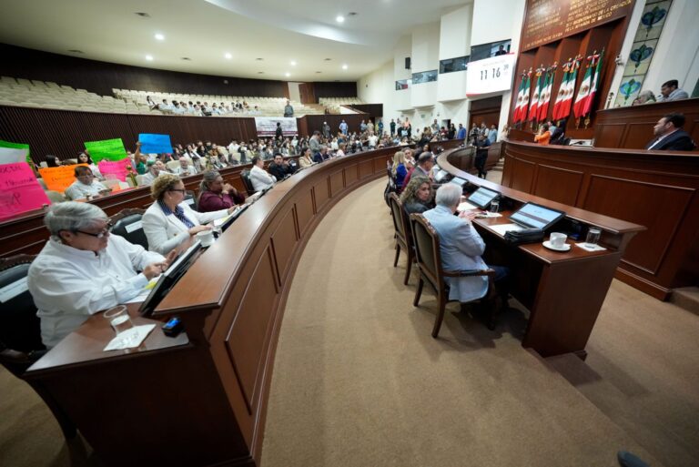 Foto lateral del Salón de Sesiones. Dos hileras de diputados y diputadas sentadas.