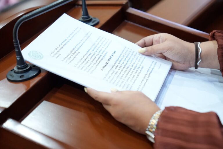 Par de manos sostiene iniciativa a la que se le da lectura en tribuna.