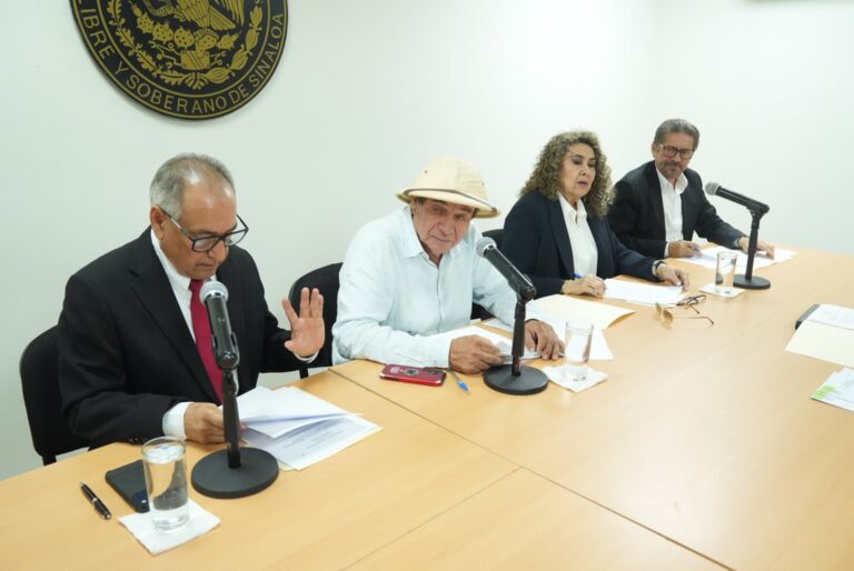 Cuatro integrantes de la Comisión revisan dictamen.
