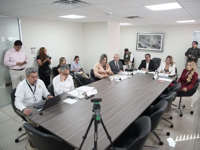 Cinco integrantes de la Comisión revisan dictamen en la Sala de Juntas de la Unidad Técnica de Evaluación.