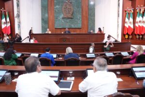Desde sus asientos, diputadas y diputados siguen la lectura de dictamen que se hace en tribuna.