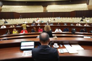 Presidente de Mesa Directiva aparece de espaldas. Al fondo sus compañeras y compañeros.