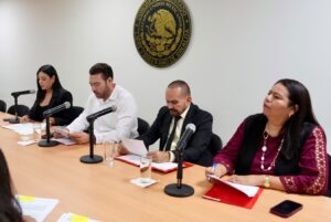 Cuatro integrantes de la comisión revisan resumen de las iniciativas.
