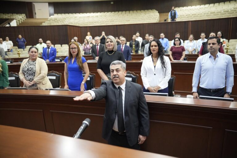 Ignacio Campa, de pie, extiende su brazo derecha. durante toma de protesta en Salón de Sesiones.