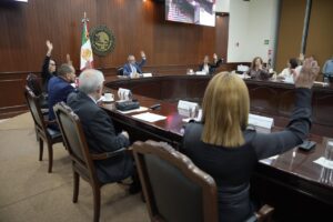Diputados y diputadas votan, desde sus asientos, durante la sesión.