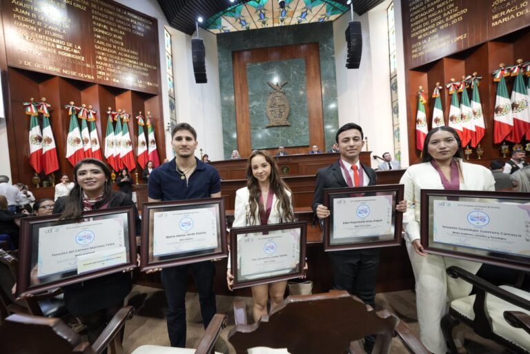 Jóvenes galardonados posan con sus premios en el Salón de Sesiones.