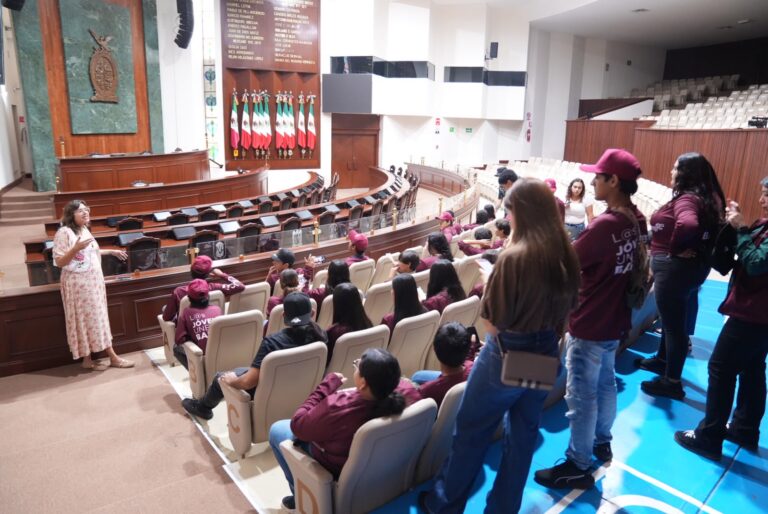 Jóvenes visitantes conocen el Salón de Sesiones.