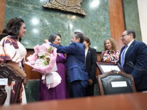 El diputado Eligio López le coloca medalla a la ganadora del premio, Analai Sipatly Valenzuela.
