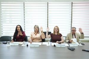 Tres diputadas y un diputado votan levantando sus manos.
